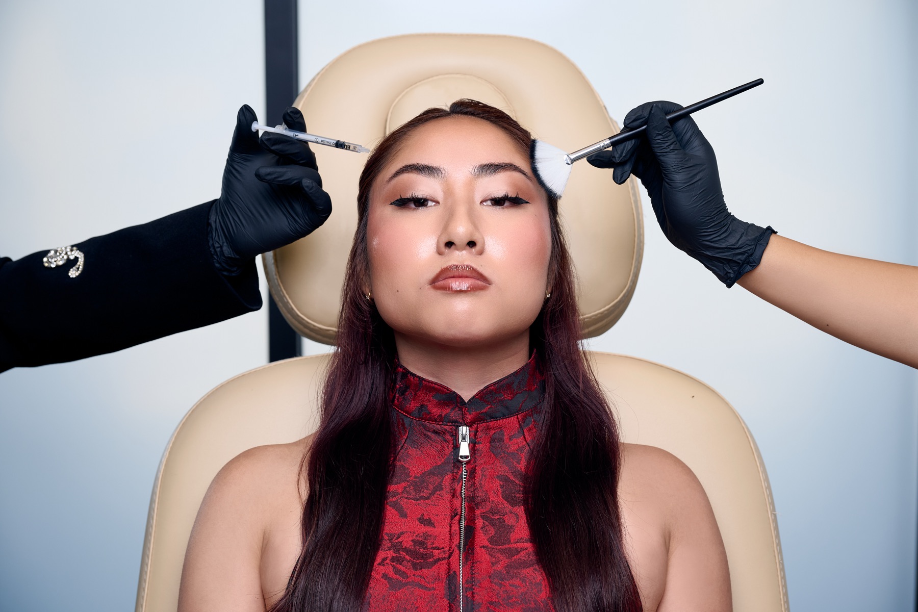 Botox treatment moment at Excell Atelier — syringe and brush framing the patient